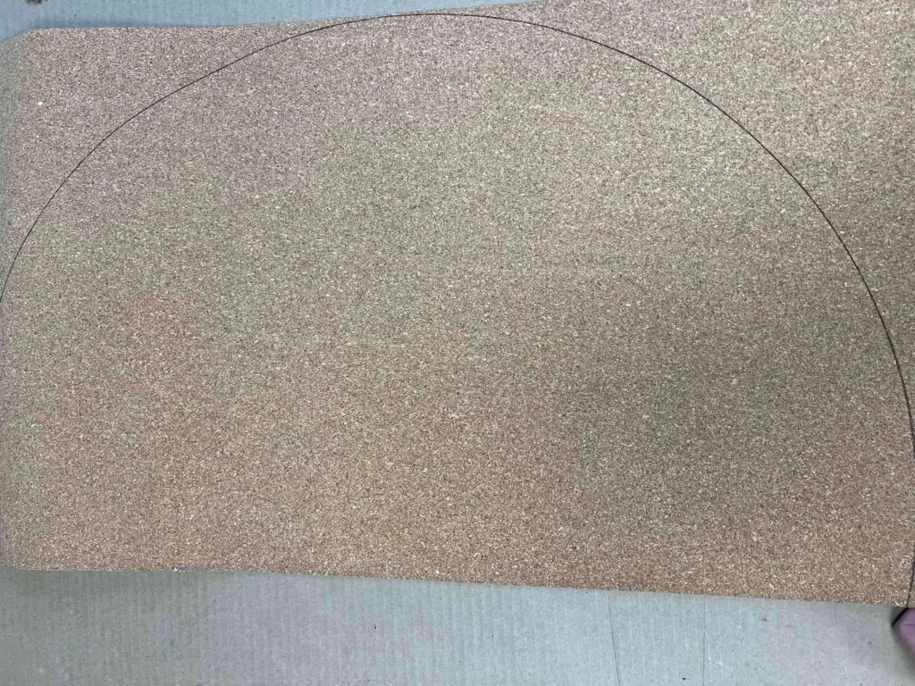 A rectangular dark tan colored panel with a semi-circle outlined in black pen.